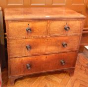 An oak chest of two short and two long drawers, on shaped bracket feet,