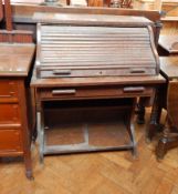 An oak roll-top writing table with undershelf,