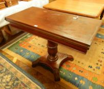 A Victorian mahogany foldover card table of rectangular form, on baluster stem and platform base,