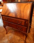 A walnut bureau, the fall-front over two drawers, on cabriole legs,