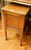 An oak side cupboard on square tapering legs,