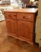 A modern pine cabinet with two short and two long drawers, cupboard to base,