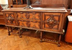 An early 20th century oak sideboard with two central drawers flanked by cupboards,