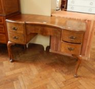 A walnut break-fronted dressing table with four flanking drawers, swan neck handles,