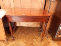 A Georgian mahogany foldover card table with ebony stringing, on turned legs,