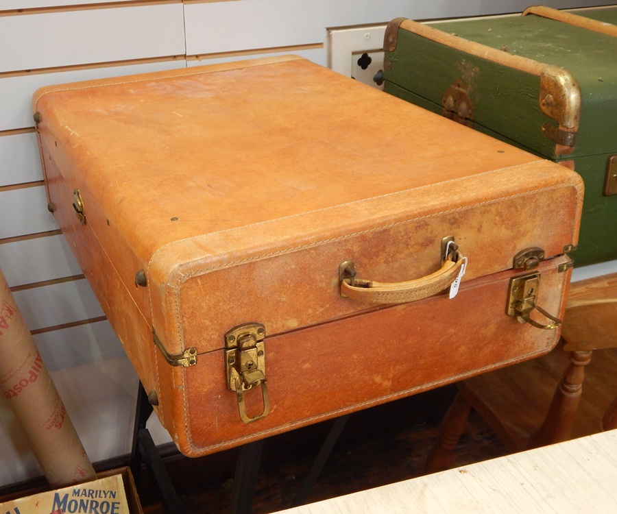 Early to mid 20th century leather suitcase of asymmetric opening with brass corners and catches,