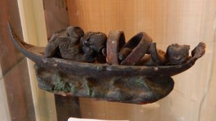 Old clay model tribal figures in a boat (damaged),