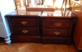 A pair of bedside chests with two short drawers, swan neck handles, on block feet,