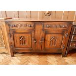 An oak sideboard with two short drawers and two cupboards, lancet carving,