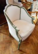 A French style bergere chair painted green with white foliate border, cream floral cushion,