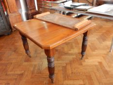 A Victorian walnut wind-out dining table with spare leaf,