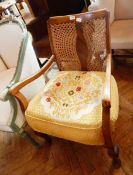 A 20th century stained beech chair with wicker patterned back and a gold floral patterned cushion