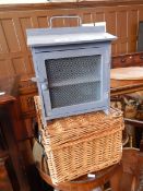 A blue painted mesh fronted storage box, a wicker basket,