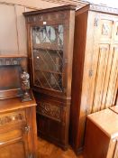 A 19th century oak corner cupboard with lunette carved frieze and coat of arms,