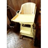 A 20th century yellow high chair with foot rest and undershelf,