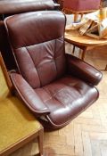 Modern brown leather tilting armchair and another similar with footstool