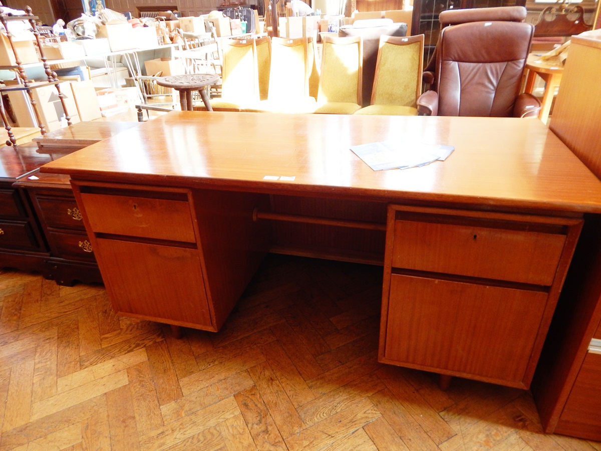 A Heals 1950's teak kneehole desk with four flanking drawers,