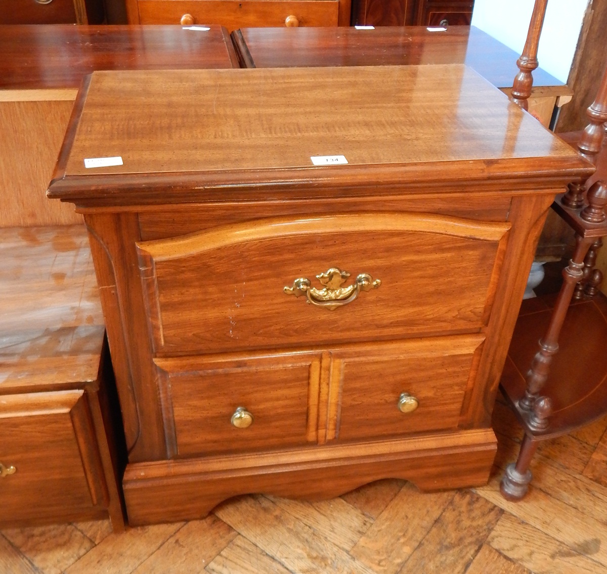 A stained small chest with one long and two short drawers, on shaped bracket feet,