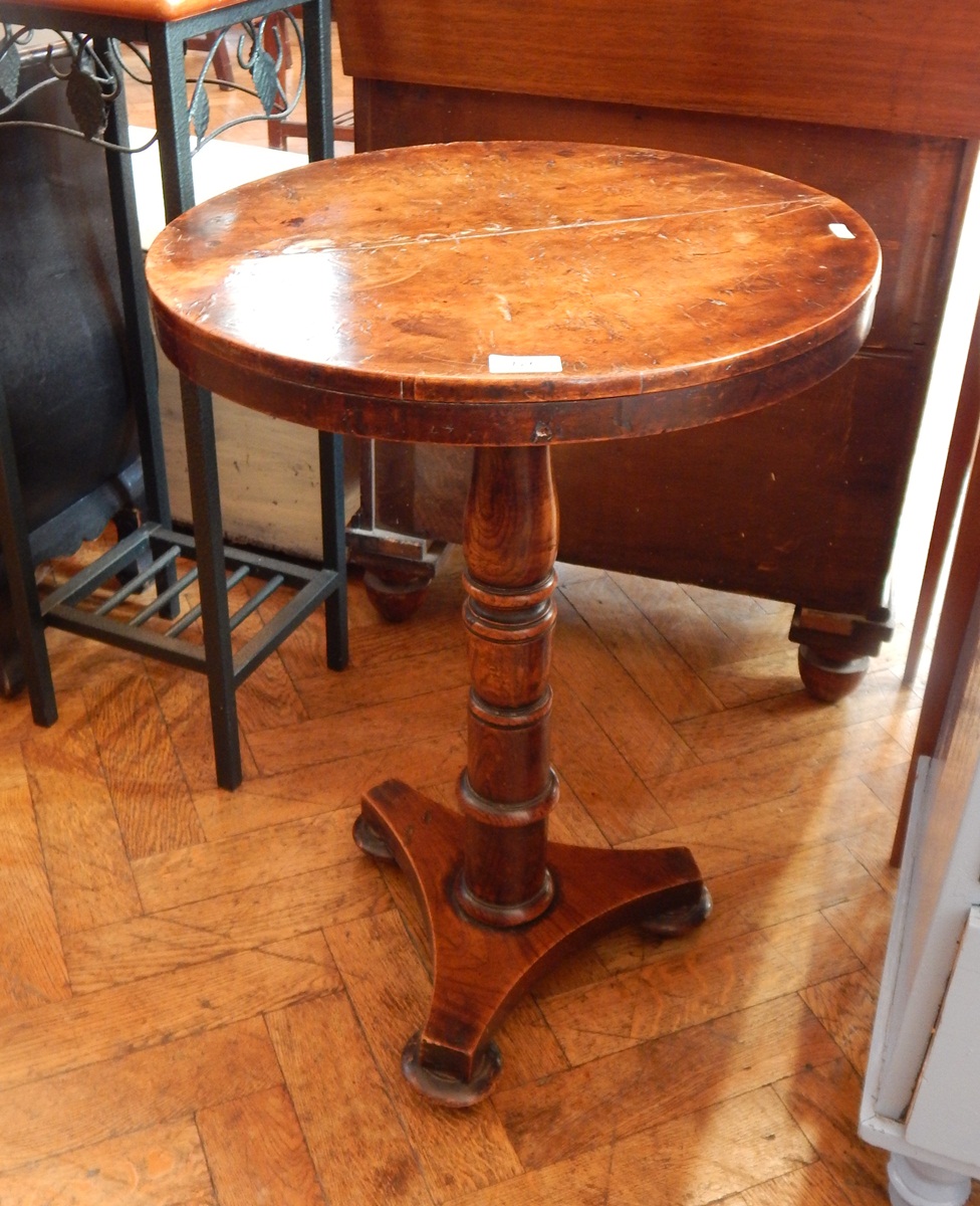 A circular walnut occasional table on turned supports,