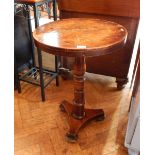 A circular walnut occasional table on turned supports,