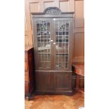 An oak display cabinet with scroll carved cornice,