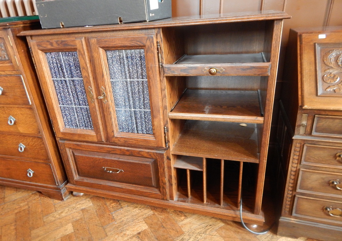 An oak side cabinet with two drawers and storage, on bun feet,