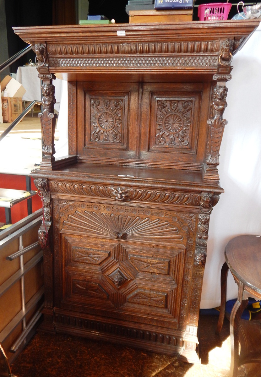 An oak sideboard with raised and panel back, with linenfold decoration,