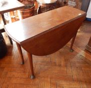 An oak drop-leaf table on bun feet,