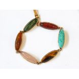 A gold bracelet set with elongated cabochons of quartz, agate, rose quartz, tiger's eye,