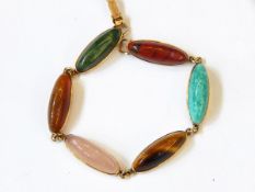 A gold bracelet set with elongated cabochons of quartz, agate, rose quartz, tiger's eye,