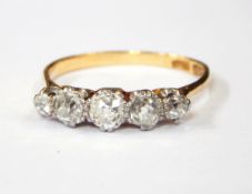 An 18ct gold and platinum five-stone ring set with five graduated white stones