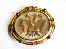 A Victorian rolled gold oval locket brooch,