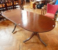 A reproduction extending pedestal dining table with single leaf insert and stringed border,