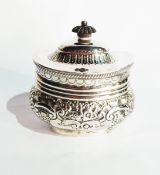 A Victorian silver tea caddy, the hinged cover with ebony finial, with overall repousse decoration,
