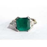 A platinum, emerald and diamond ring set central emerald (5.
