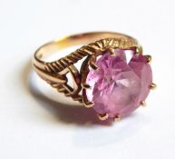 A 9ct gold ring set with a circular pink synthetic corundum,