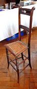 A 19th century child's stained beech ladderback correctional chair with rush seat and bead borders,