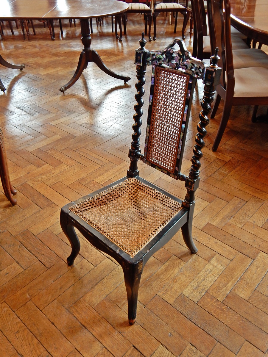 A Victorian black lacquer chair with cane seat and back rest,