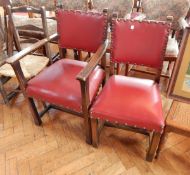 An oak carver's chair with red leather seat covers together with matching chair