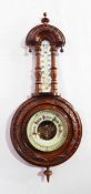 Carved walnut barometer with turned finials and arched top,