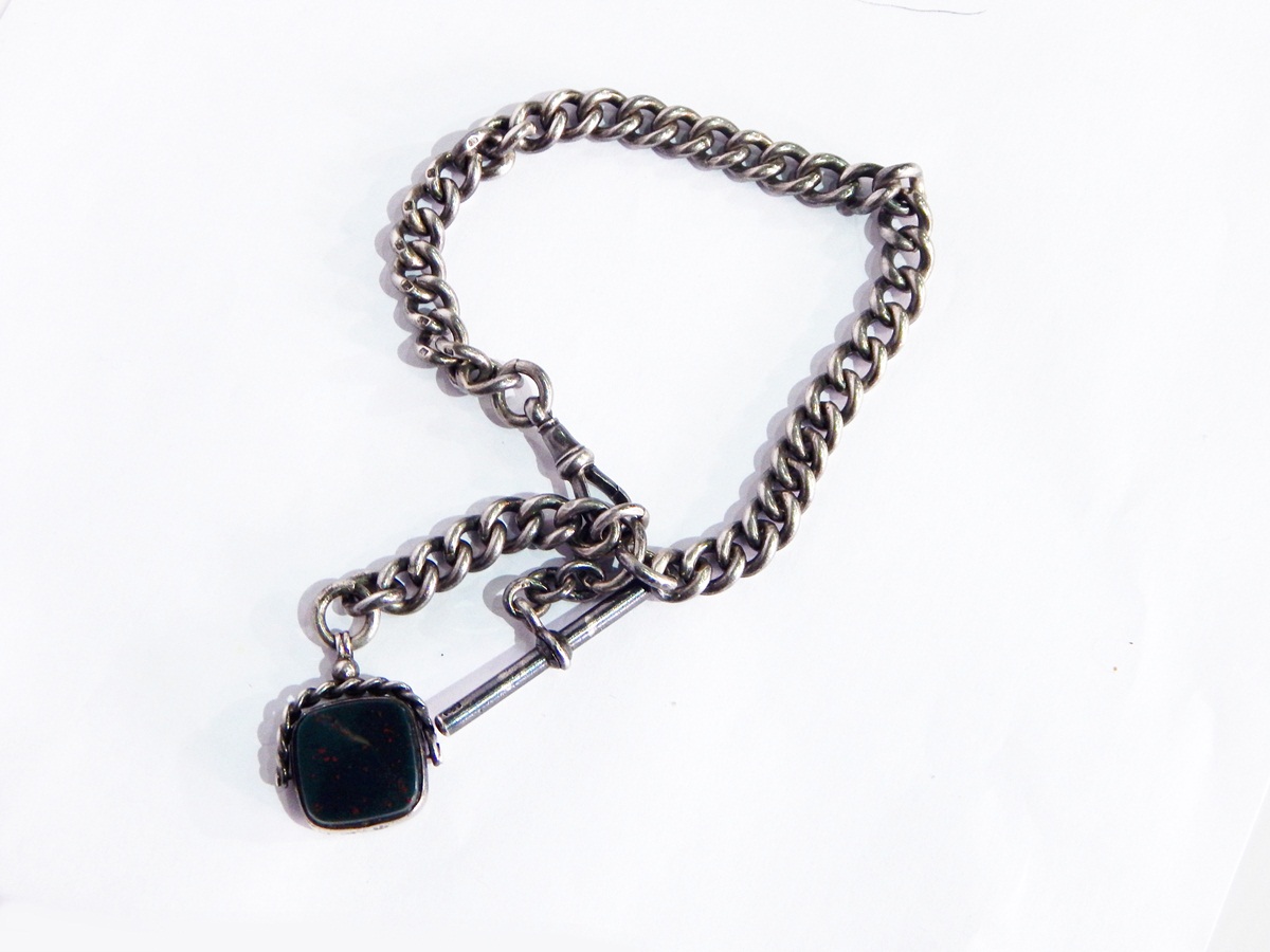 A silver albert chain, curb link with swivel seal fob,