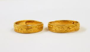 Two Chinese gold-coloured wedding rings, each decorated with dragons, with character marks, approx.