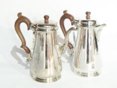 A George V silver coffee pot of plain tapering form, with scrollwork spout and wooden handle,