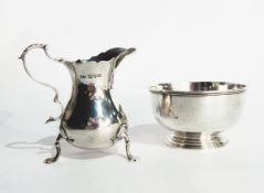 A silver cream jug with 'S' scroll handle, scroll shaped tripod supports with pad feet,