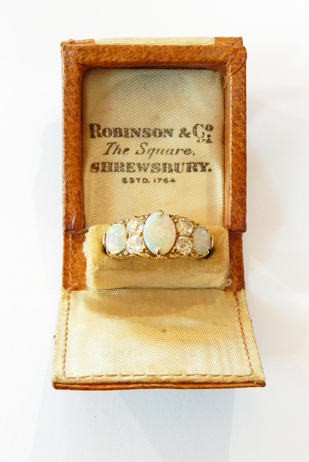 An 18ct gold, opal and diamond dress ring set three oval opals and four diamonds,