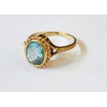 A 9ct gold ring set with an oval mixed cut aquamarine within a ropetwist border