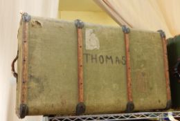 A canvas wood bound trunk bearing various labels,