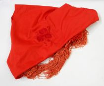 Fringed red shawl decorated with raised flowers