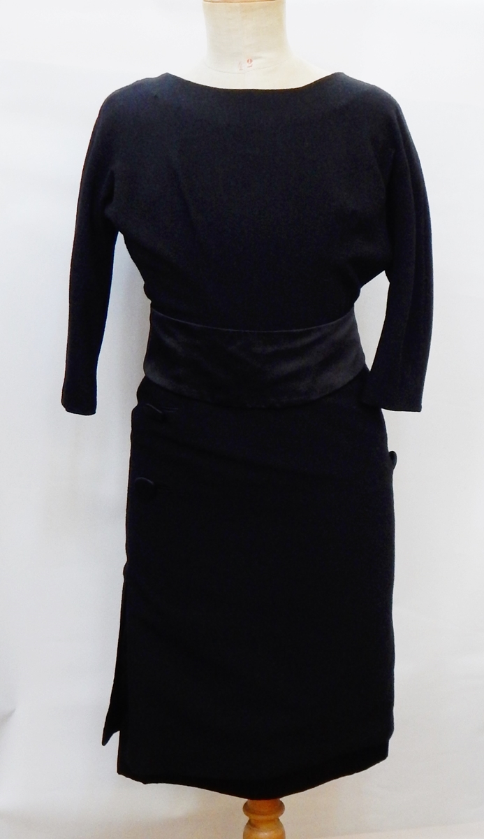A black wool crepe 1950's cocktail dress with satin underskirt, satin button detail, satin sash,