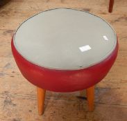 Small circular leather footstool with grey leather top and red band, on circular tapering legs,